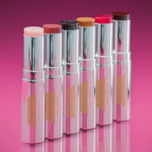 Start 49 Aora Mexico Acaríciame Solid Lip Serum - kolekcja nawilżających balsamów do ust w sztyfcie w sześciu odcieniach, w srebrnych opakowaniach na intensywnie różowym tle.