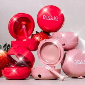 Doll 10 Peptide Bounce Lip Treatment - kolekcja różowych balsamów do ust w otwartych i zamkniętych opakowaniach z aplikatorami oraz truskawkami w tle.