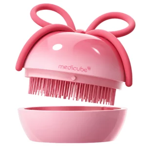 Start 45 MEDICUBE Ribbon Cherry Glass Hair Brush - różowa szczotka z kokardą pokazana nad dopasowanym ochronnym etui na białym tle.