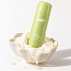 skincare 2 SKIT Glutamilk Essence Toner - rytuał świetlistej skóry, zielona butelka toniku-esencji zanurzona w kremowej konsystencji w ceramicznej miseczce na jasnym tle.