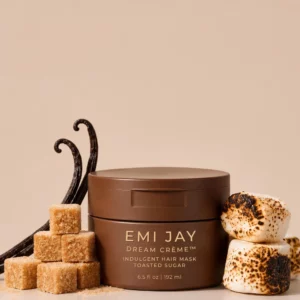 Start 163 EMI JAY Dream Crème Indulgent Hair Mask Toasted Sugar 192 ml - luksusowa maska wygładzająca do włosów w brązowym słoiczku ze złotymi napisami, otoczona kostkami brązowego cukru, laskami wanilii i opiekanymi piankami marshmallow na beżowym tle.