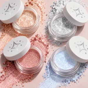Cztery odcienie brokatowych cieni do powiek Half Magic GlitterPuck w otwartych słoiczkach - szampańskie złoto, srebro, róż i opalizujący błękit. Intensywnie lśniące pigmenty i rozsypane drobinki brokatu podkreślają wielowymiarowy blask oraz efekt metalicznej tafli.