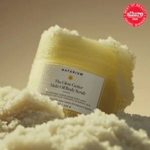 Start 60 Naturium The Glow Getter Multi-Oil Body Scrub - odżywczy peeling do ciała z olejkami, kryształkami cukru, gliceryną i skwalanem, przedstawiony w kremowej konsystencji peelingu. Produkt wyróżniony nagrodą Allure Best of Beauty 2026.