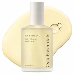 Start 54 Oak Essentials Dew Body Oil - olejek do pielęgnacji ciała w minimalistycznej butelce, pokazany na tle złocistej konsystencji olejku. Kosmetyk do nawilżania, wygładzania i nadawania suchej skórze zdrowego, świetlistego wyglądu.